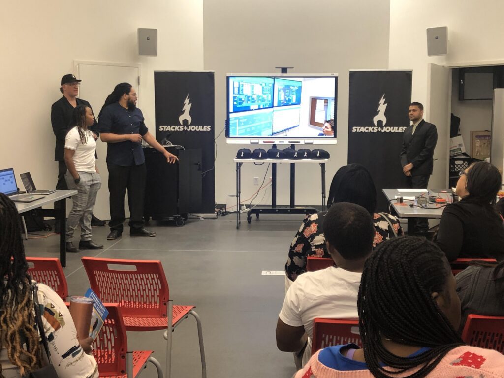 Stacks and Joules student present in a classroom in front of a screen.