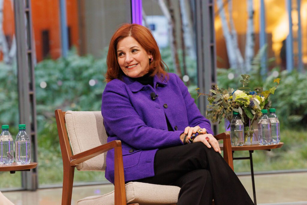 Christine Quinn, in a bright purple blazer, on stage at the 2025 NYCETC Conference.