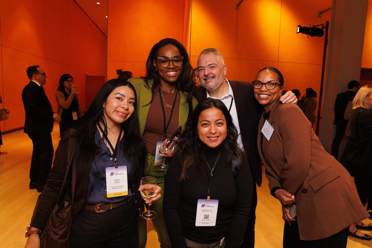 A group of five professionals smiling at the 2025 NYCETC Conference.