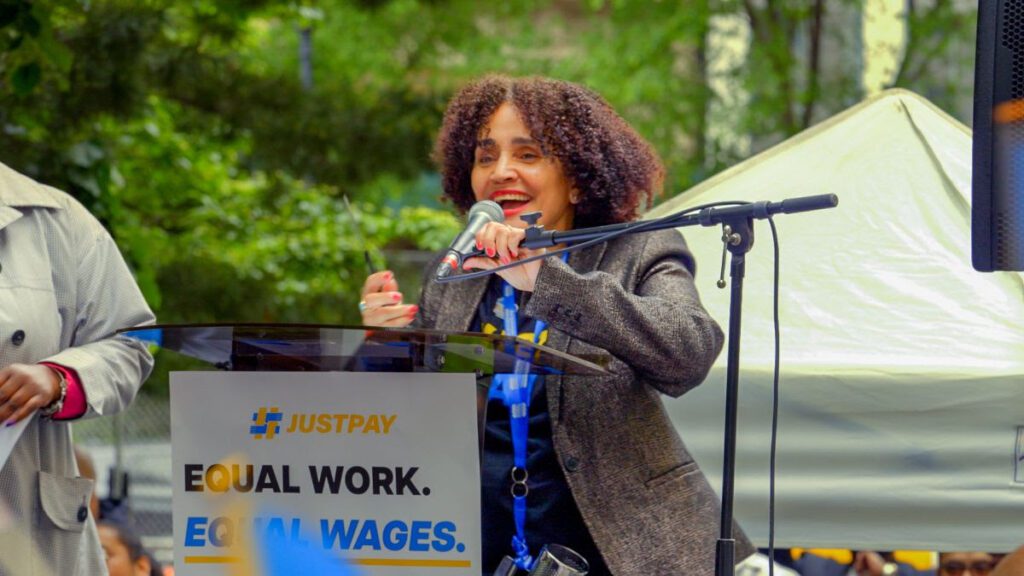 Maria Lizardo speaks from the podium at the Just Pay rally.